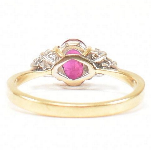 30 - A hallmarked 18ct gold, ruby and diamond ring. The ring set with a central oval cut ruby flanked by ... 