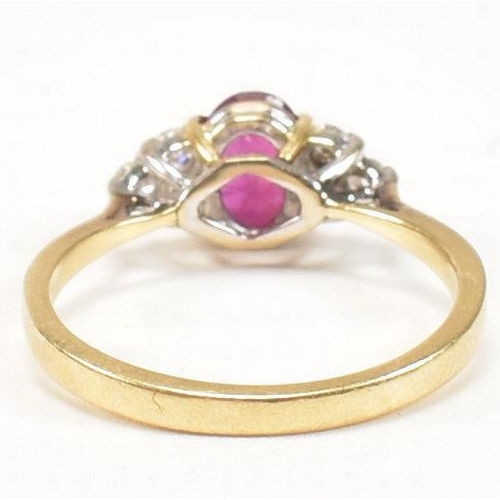 30 - A hallmarked 18ct gold, ruby and diamond ring. The ring set with a central oval cut ruby flanked by ... 