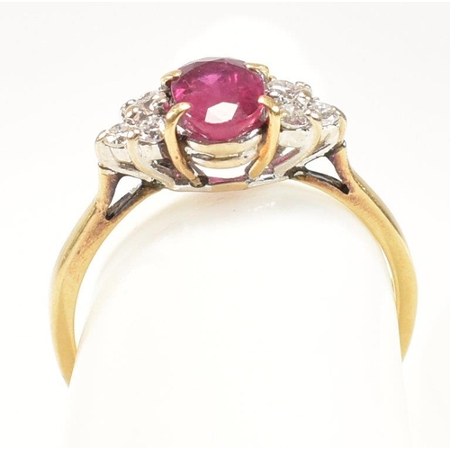 30 - A hallmarked 18ct gold, ruby and diamond ring. The ring set with a central oval cut ruby flanked by ... 