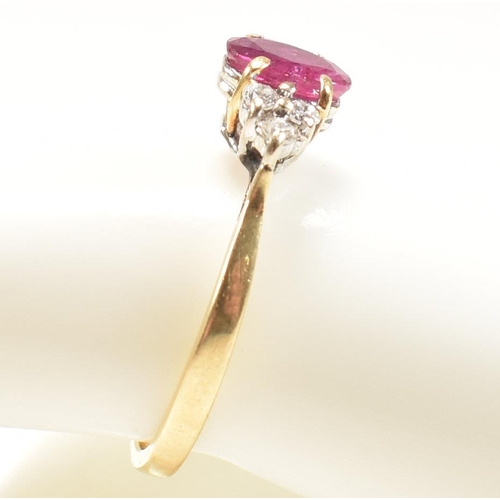 30 - A hallmarked 18ct gold, ruby and diamond ring. The ring set with a central oval cut ruby flanked by ... 