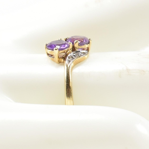 302 - A hallmarked 9ct gold, amethyst and diamond cross over ring. The ring having two round cut amethysts... 