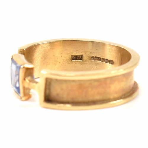 321 - A hallmarked 9ct gold and sapphire ring. The ring set with a single bezel set princess cut sapphire ... 