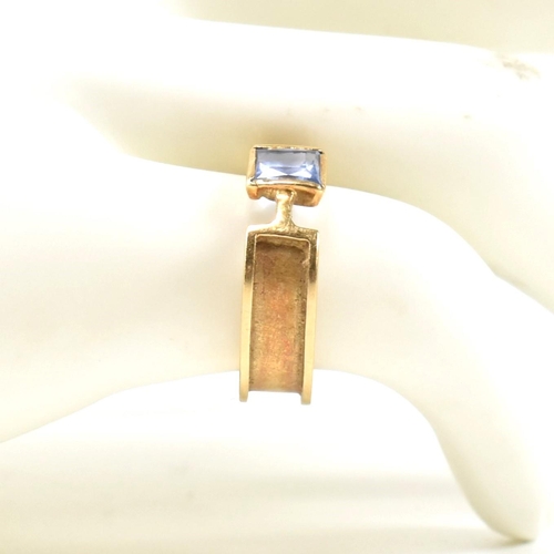 321 - A hallmarked 9ct gold and sapphire ring. The ring set with a single bezel set princess cut sapphire ... 