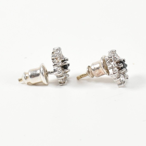 322 - A pair of hallmarked 9ct gold, CZ and sapphire cluster earrings. The stud earrings set with a centra... 