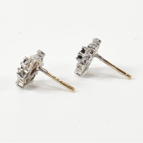 322 - A pair of hallmarked 9ct gold, CZ and sapphire cluster earrings. The stud earrings set with a centra... 