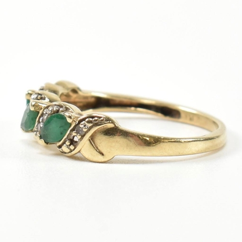 328 - A 9ct gold, diamond and emerald twist band ring. The ring set with three marquise cut emeralds inter... 