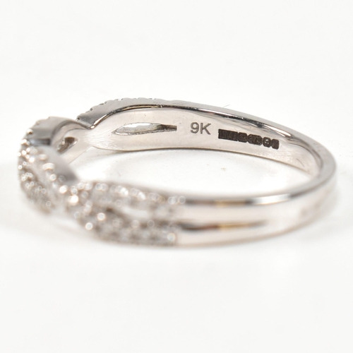 33 - A hallmarked 9ct gold and diamond crossover ring. The ring formed with entwined channels of round br... 