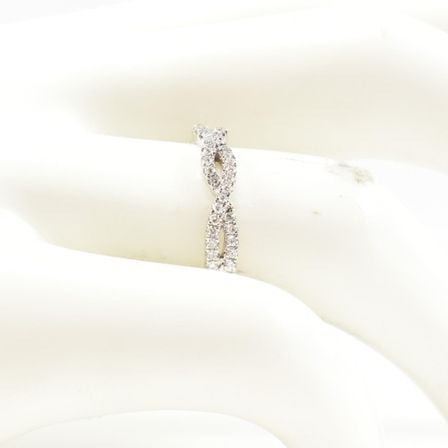 33 - A hallmarked 9ct gold and diamond crossover ring. The ring formed with entwined channels of round br... 