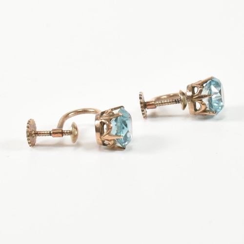 335 - A pair of 9ct gold and zircon earrings. The earrings having a single six claw set round cut zircon t... 