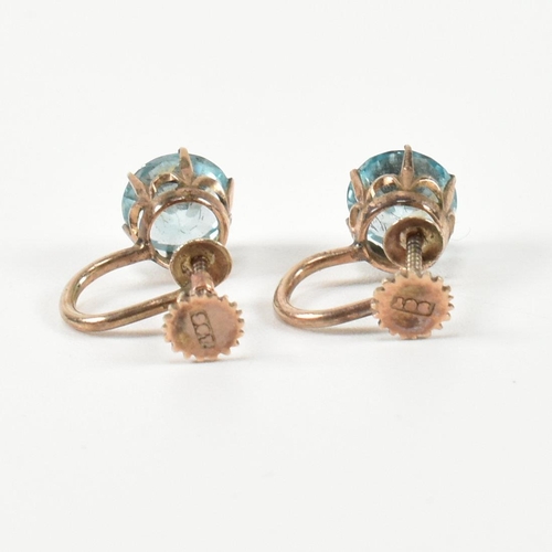 335 - A pair of 9ct gold and zircon earrings. The earrings having a single six claw set round cut zircon t... 