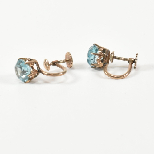 335 - A pair of 9ct gold and zircon earrings. The earrings having a single six claw set round cut zircon t... 