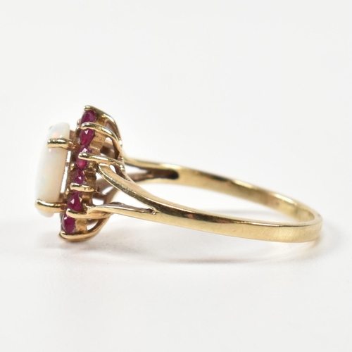 347 - A hallmarked 9ct gold, opal and ruby cluster ring. The ring having a central opal cabochon surrounde... 