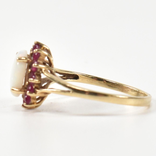 347 - A hallmarked 9ct gold, opal and ruby cluster ring. The ring having a central opal cabochon surrounde... 