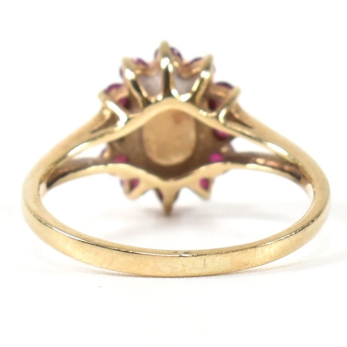 347 - A hallmarked 9ct gold, opal and ruby cluster ring. The ring having a central opal cabochon surrounde... 