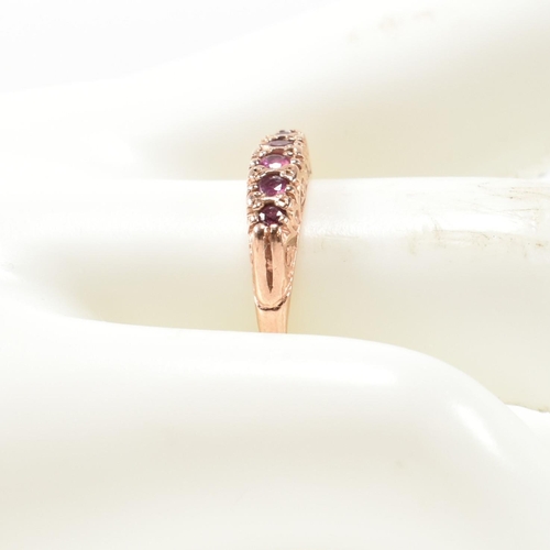 348 - A hallmarked 9ct rose gold and ruby five stone gypsy ring. The ring having five graduating round cut... 