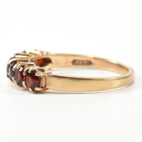 353 - A hallmarked 9ct gold and garnet seven stone half hoop ring. The 9ct gold ring having a row of seven... 