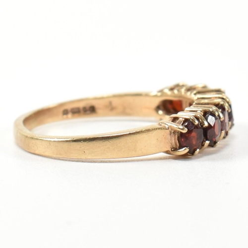 353 - A hallmarked 9ct gold and garnet seven stone half hoop ring. The 9ct gold ring having a row of seven... 