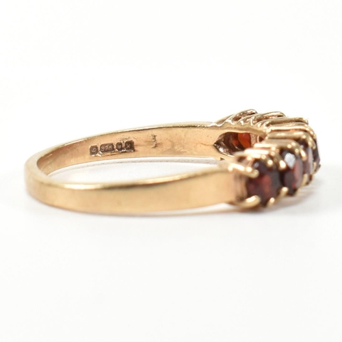 353 - A hallmarked 9ct gold and garnet seven stone half hoop ring. The 9ct gold ring having a row of seven... 