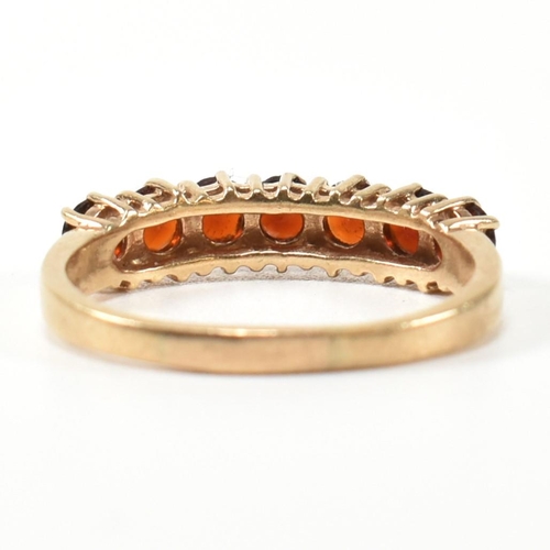 353 - A hallmarked 9ct gold and garnet seven stone half hoop ring. The 9ct gold ring having a row of seven... 