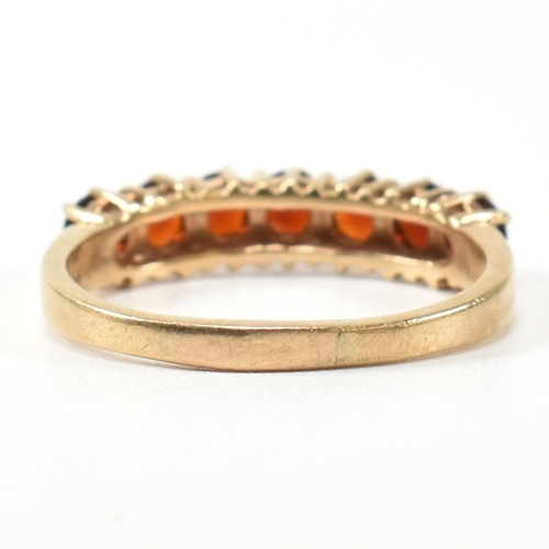 353 - A hallmarked 9ct gold and garnet seven stone half hoop ring. The 9ct gold ring having a row of seven... 