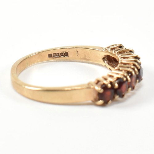 353 - A hallmarked 9ct gold and garnet seven stone half hoop ring. The 9ct gold ring having a row of seven... 