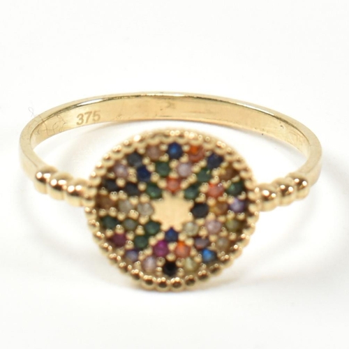 356 - A 9ct gold, ruby and gem set disc ring. The 9ct gold ring having a disc set with multi-coloured roun... 