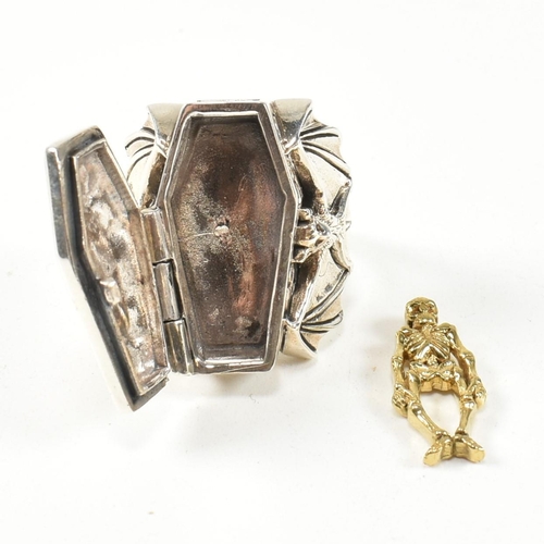 357 - A silver coffin locket ring. The ring in form of a coffin having hinged compartment that opens to re... 