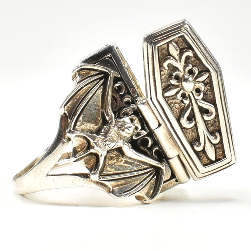 357 - A silver coffin locket ring. The ring in form of a coffin having hinged compartment that opens to re... 