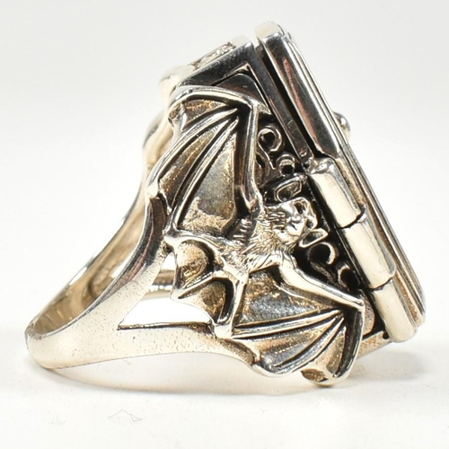 357 - A silver coffin locket ring. The ring in form of a coffin having hinged compartment that opens to re... 