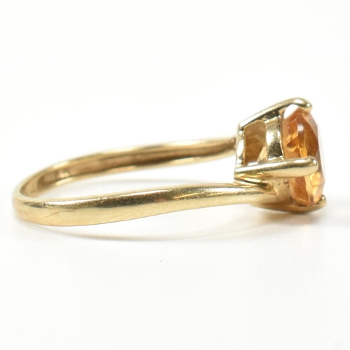 366 - A hallmarked 9ct gold and citrine cross over ring. The ring having a compass four claw set round cut... 