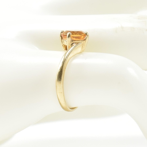 366 - A hallmarked 9ct gold and citrine cross over ring. The ring having a compass four claw set round cut... 