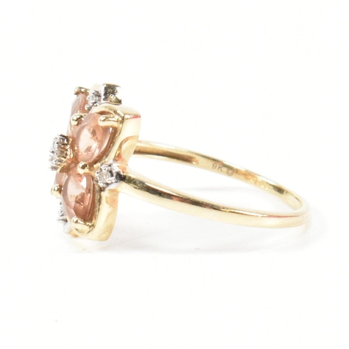 370 - A hallmarked 9ct gold sunstone and diamond cluster ring. The ring having a clover shaped mount set w... 