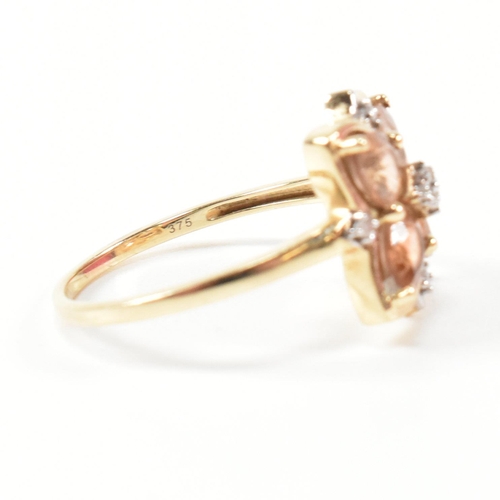 370 - A hallmarked 9ct gold sunstone and diamond cluster ring. The ring having a clover shaped mount set w... 