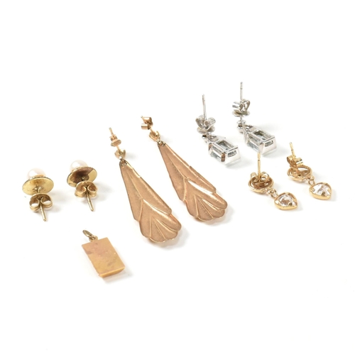 375 - A collection of 9ct gold earrings and a yellow metal gold ingot necklace pendant/charm. The four ear... 