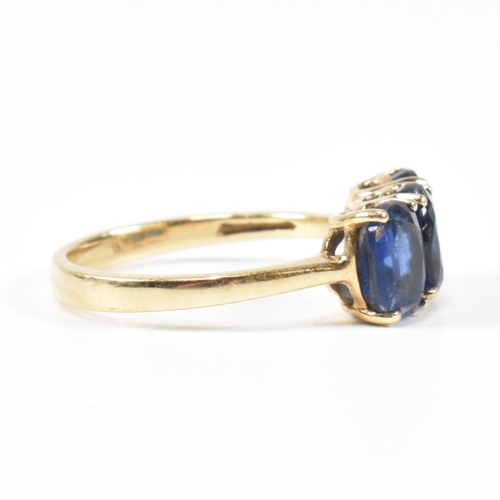 382 - A hallmarked 9ct gold and synthetic sapphire three stone ring. The ring having three four claw set o... 