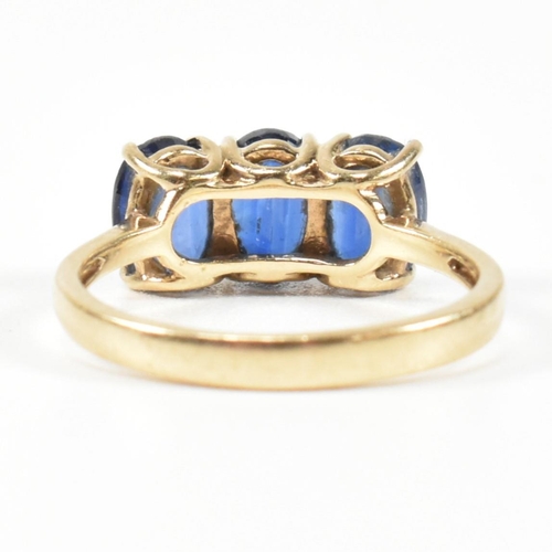 382 - A hallmarked 9ct gold and synthetic sapphire three stone ring. The ring having three four claw set o... 