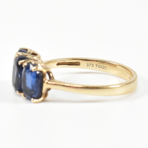 382 - A hallmarked 9ct gold and synthetic sapphire three stone ring. The ring having three four claw set o... 