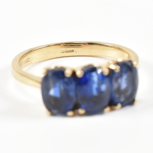 382 - A hallmarked 9ct gold and synthetic sapphire three stone ring. The ring having three four claw set o... 