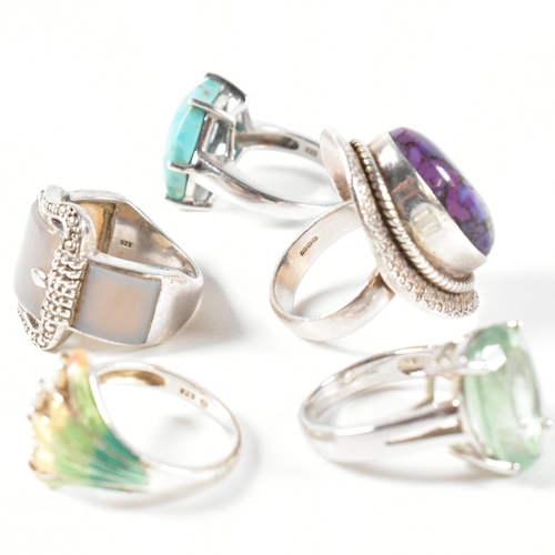 390 - A collection of 925 silver, gem set and enamel rings. The rings to include a silver and gradient-col... 