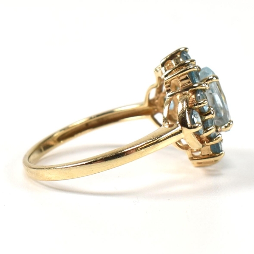 398 - A hallmarked 9ct gold and topaz cluster ring. The ring having a central four claw set oval cut topaz... 