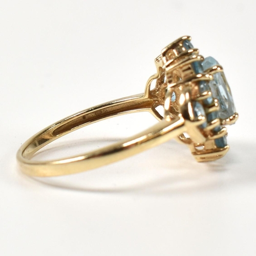 398 - A hallmarked 9ct gold and topaz cluster ring. The ring having a central four claw set oval cut topaz... 