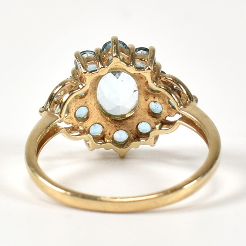 398 - A hallmarked 9ct gold and topaz cluster ring. The ring having a central four claw set oval cut topaz... 