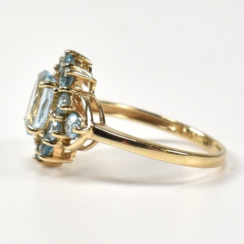 398 - A hallmarked 9ct gold and topaz cluster ring. The ring having a central four claw set oval cut topaz... 