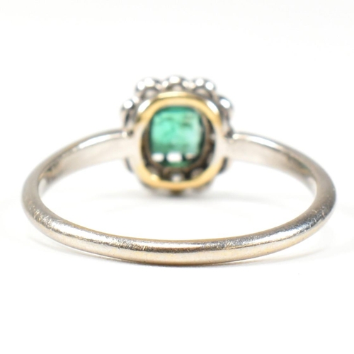 4 - A 1920s emerald and diamond cluster ring. The ring set with a central emerald framed by old cut diam... 