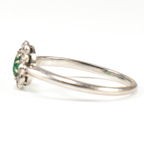 4 - A 1920s emerald and diamond cluster ring. The ring set with a central emerald framed by old cut diam... 