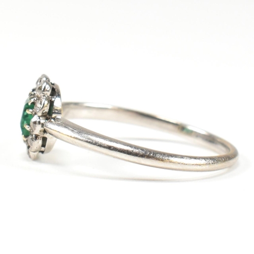 4 - A 1920s emerald and diamond cluster ring. The ring set with a central emerald framed by old cut diam... 