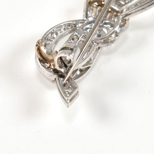 40 - An Art Deco platinum gold and diamond ribbon bow brooch pin. The brooch set with single baguette and... 