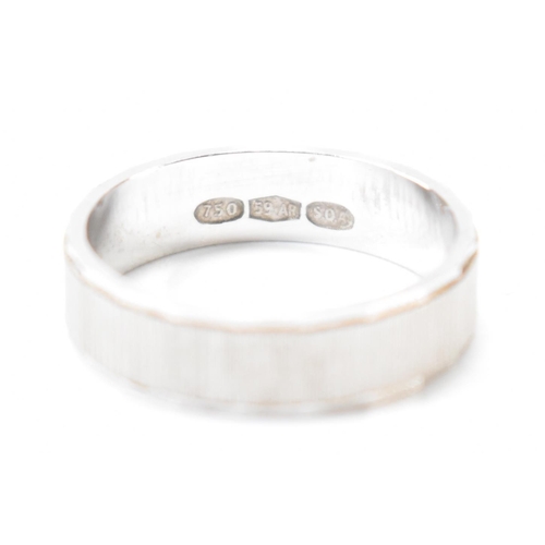 403 - An Italian 18ct white gold band ring. The ring having textured sides with faceted borders. Italian a... 