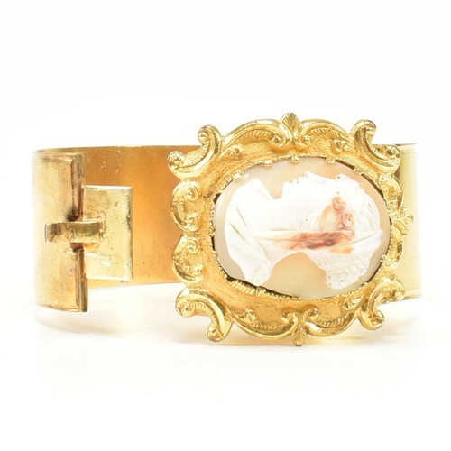 415 - A 19th century shell cameo double hinged gilt bangle. The Georgian bangle having a central carved ca... 