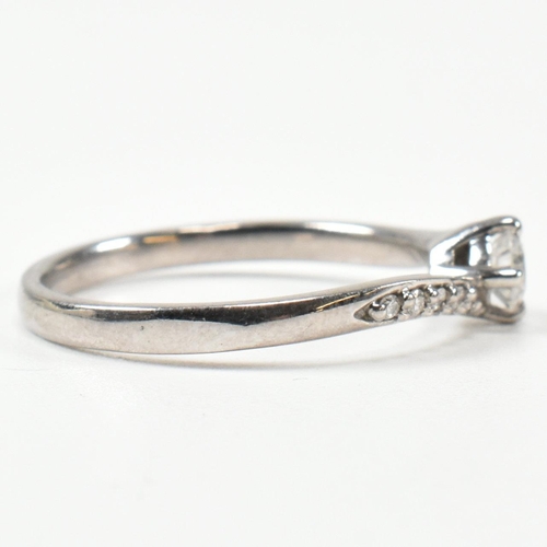 425 - A hallmarked 18ct white gold and diamond crossover ring. The ring set with a central button claw set... 